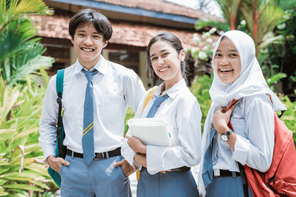 Siswa SMA tersenyum di halaman sekolah